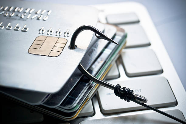 Credit card phishing Phishing - a credit card with a fish hook trying to steal personal data on a computer keyboard / financial data theft hook equipment photos stock pictures, royalty-free photos & images