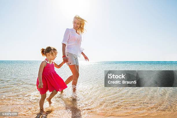 Mother And Daughter Walking At The Beach Stock Photo - Download Image Now - Child, Offspring, Outdoors