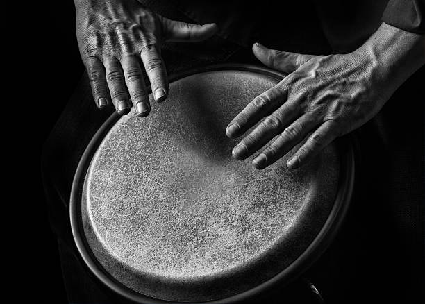 Low key picture  of a bongo Player. Black background .Detail  shot Picture is toned.