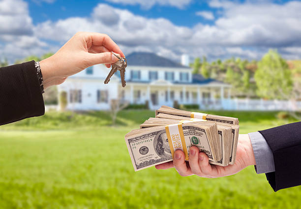 Handing Over Cash For House Keys in Front of Home stock photo