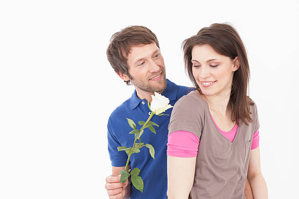 istock Man giving rose to woman, smiling 533744243