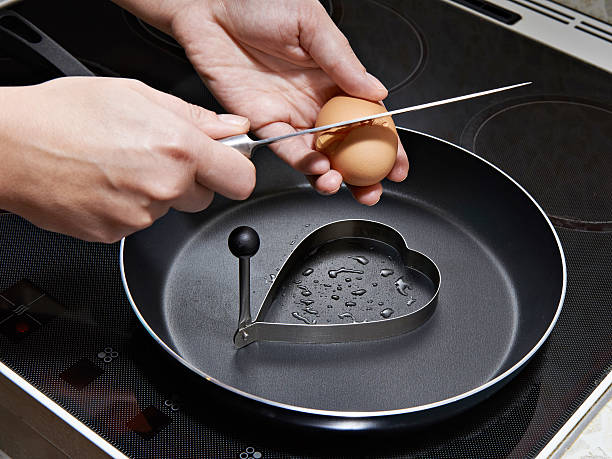 istock Woman preparing fried eggs in heart form 533745475