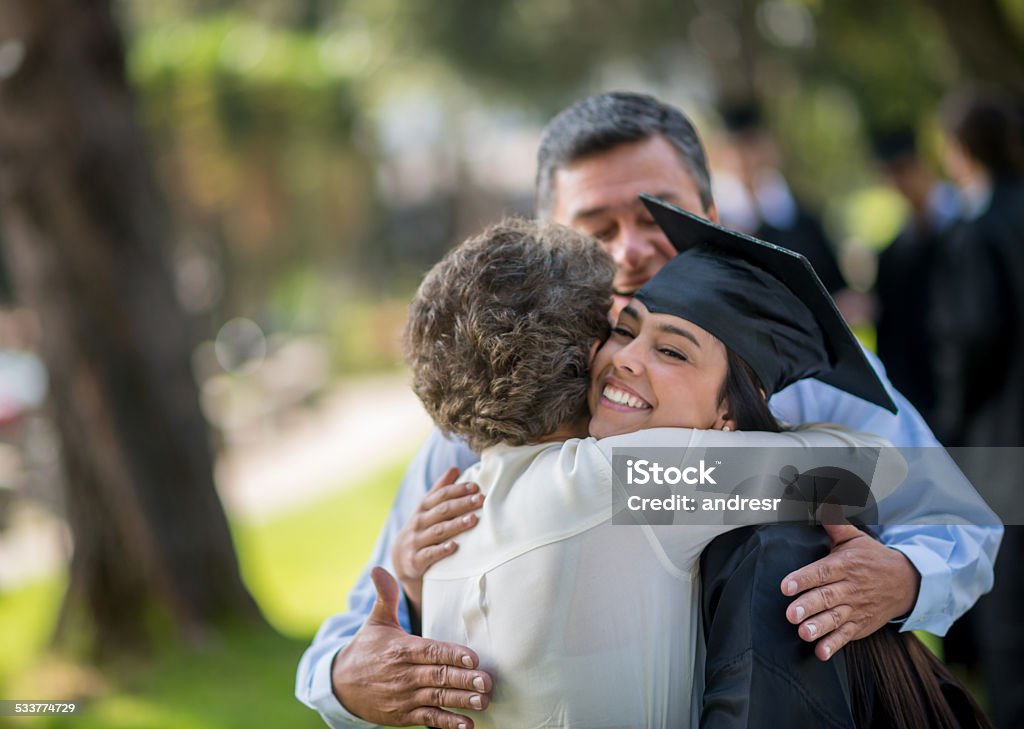 Happy graduation day Happy graduation day - family hugging a female student Graduation Stock Photo