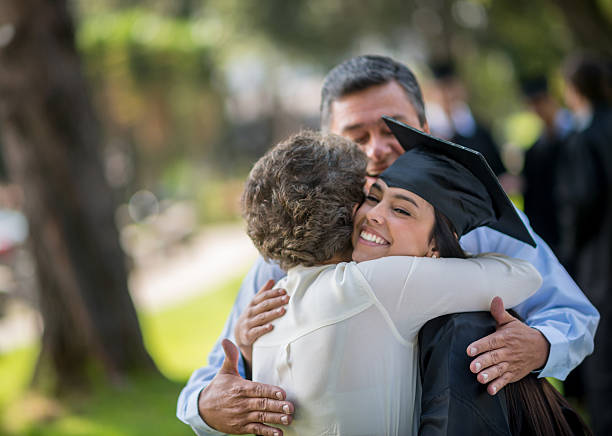 Happy graduation day Happy graduation day - family hugging a female student college student and parent stock pictures, royalty-free photos & images