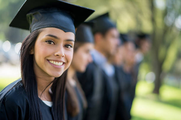 Woman on her graduation day Happy woman on her graduation day with a group of students graduation clothing stock pictures, royalty-free photos & images