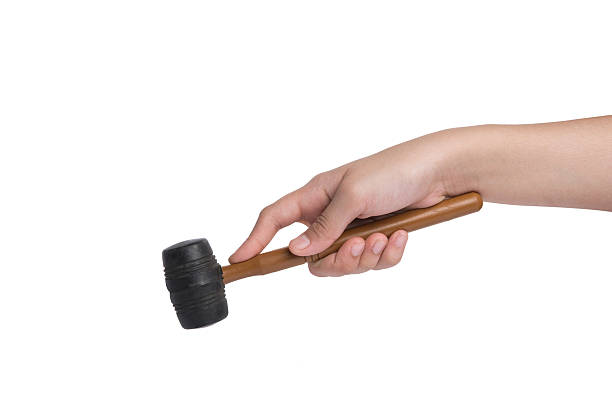 istock woman's hand holding a rubber mallet on white background 533775491