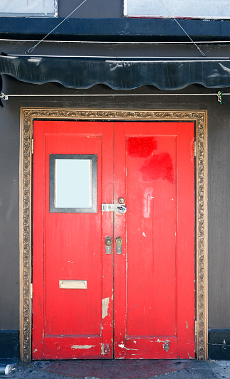 Red door entrance to sketchy nightclub. Vertical.