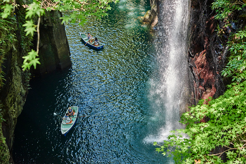 Takachiho, Japan - September 28, 2014: two boats with tourist nearby the Manai Waterfall at the Takachiho Gorge.