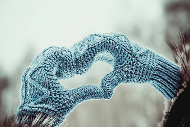 Girl with heart shaped hands in the gloves outdoor