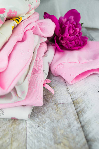 Pink layette for a newborn baby girl with peone Pink layette for a newborn baby girl with peone peone stock pictures, royalty-free photos & images