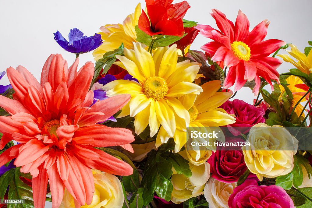 vase with colorful flowers fall over a detail of colorful fabric flowers 2015 Stock Photo