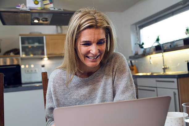 istock Happy middle-aged attractive woman using laptop 533836466