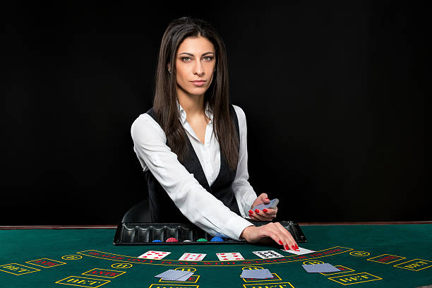 The beautiful girl, dealer, behind a table for poker stock photo