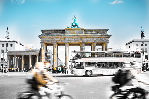 The Brandenburg Gate surrounded by the hurly-burly of the Berlin city-life. The hazy vehicles show the liveliness of the city.