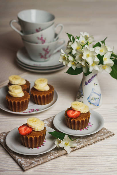 muffin de banana com morango em fundo de madeira - autumn banana breakfast close up - fotografias e filmes do acervo