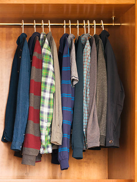 legere kleidung für männer auf einem kleiderbügel im kleiderschrank - polo shirt multi colored clothing variation stock-fotos und bilder