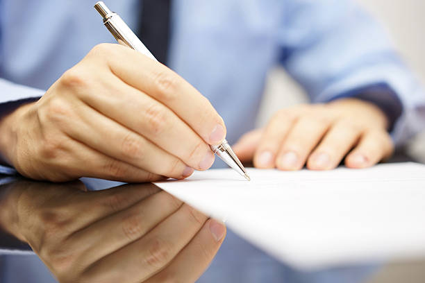 istock businessman is writing a letter or signing a agreement 533850613