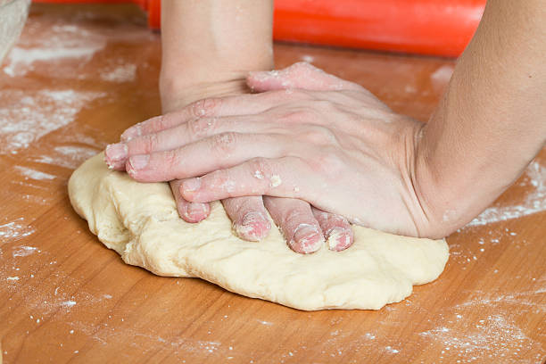 istock male hands kneading dough on table 533852211