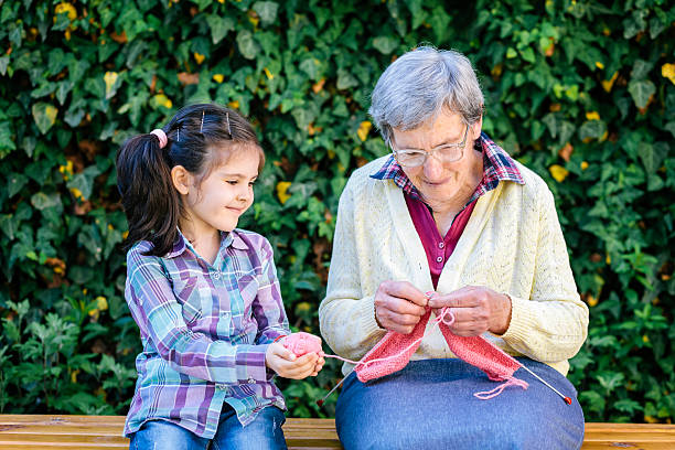 бабушка и внучка - grandmother knitting senior women senior adult стоковые фото и изображения