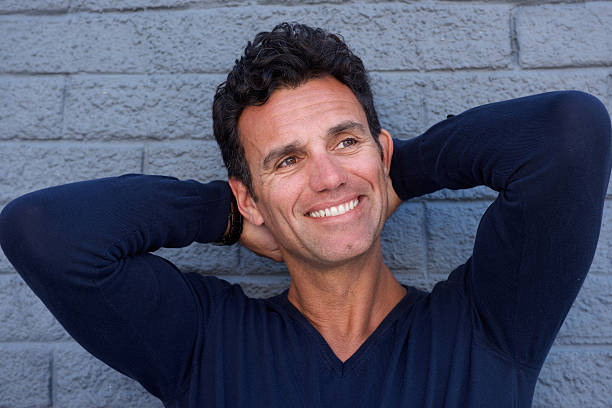 istock Close up handsome mature man smiling with hands behind head 533856850