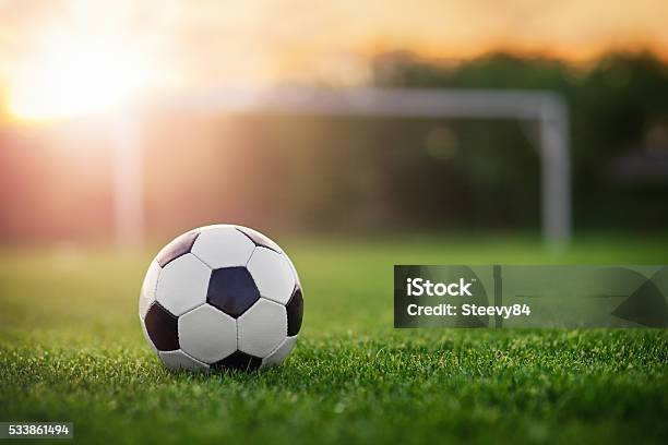 Football In The Sunset Stock Photo - Download Image Now - Soccer Field, Soccer Ball, Soccer