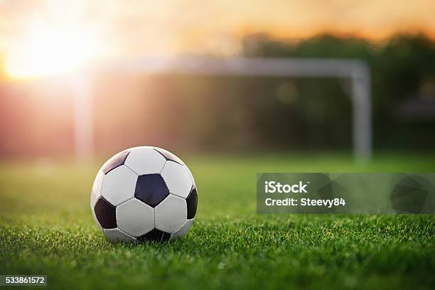 Football In The Sunset Stock Photo - Download Image Now - Soccer Ball, Soccer, Soccer Field