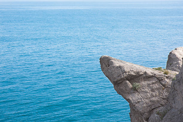 High mountain cliff at the calm sea background