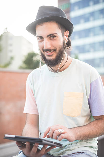 istock young handsome hipster gay modern man using tablet 533887141