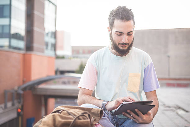 istock young handsome hipster gay modern man using tablet 533887165