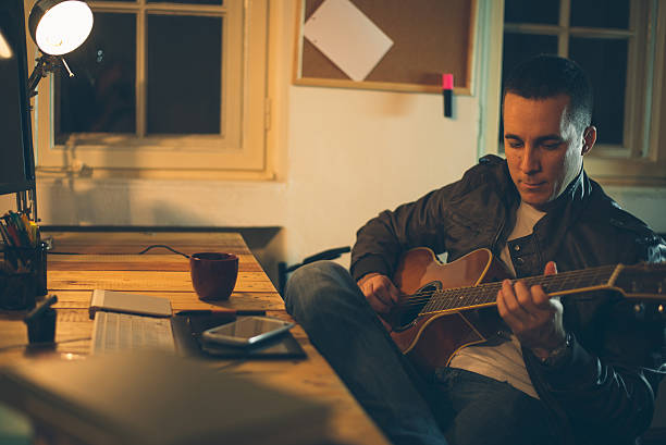 istock Man playing guitar at home office 533888899