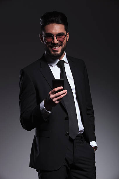 istock business man smiling while holding a phone 533889147