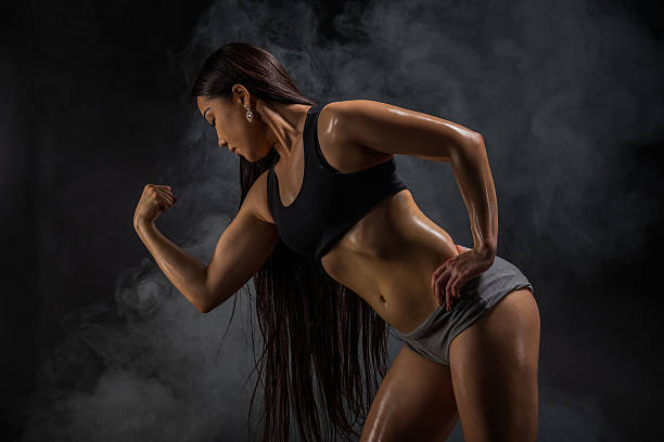 istock Young muscular woman posing on black 533892710