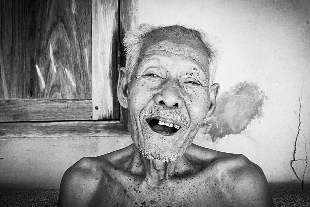 portrait of bald and bearded sarcasticly laughing senior man, isolated on white
