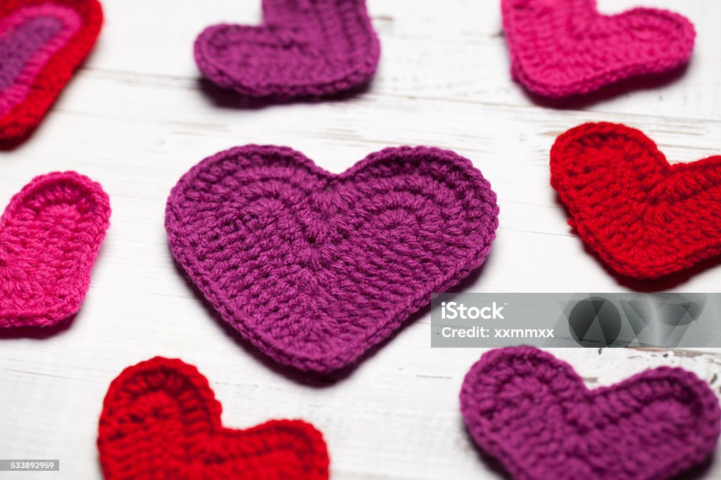 Crochet hearts on white table Crochet hearts on white table. This file is cleaned and retouched. 2015 Stock Photo