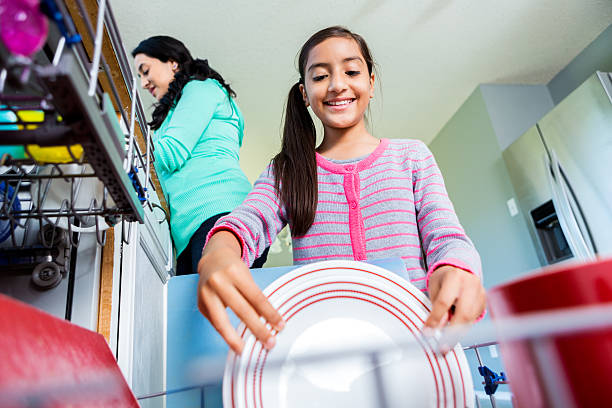 pré-adolescentes feliz menina ajuda a mãe na cozinha - family cheerful family with one child texas imagens e fotografias de stock