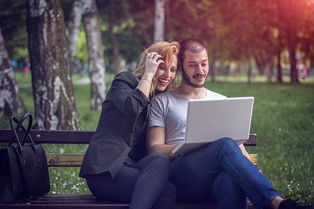 istock Young couple using laptop in park 533893804