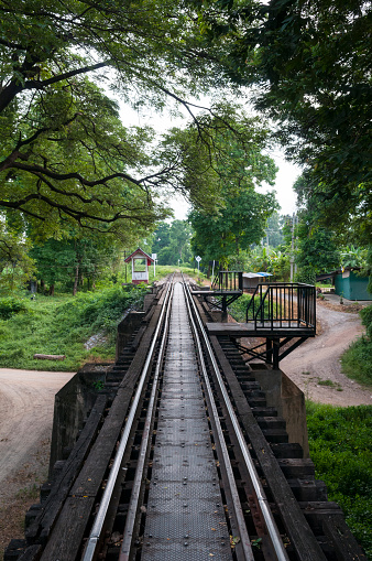 Train track leading off the Bridge on the River Kwai in Kanchanaburi, Thailand. The bridge was built by Allied POW labor during World War II, part of a railway going from Thailand to Burma.