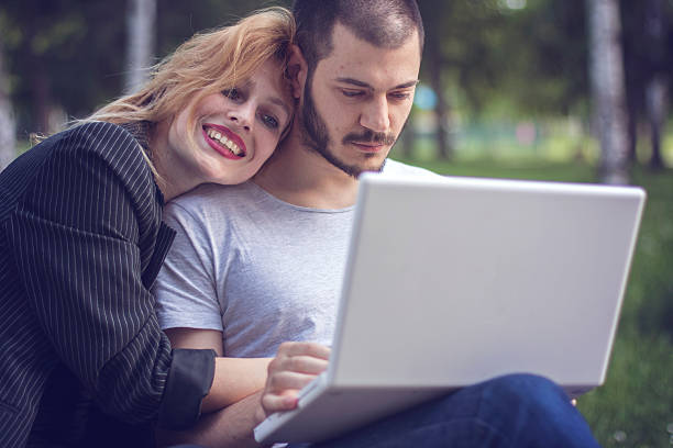 istock Young couple using laptop in park 533896126