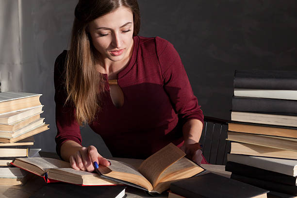 istock girl sits books and reading a book 533896130