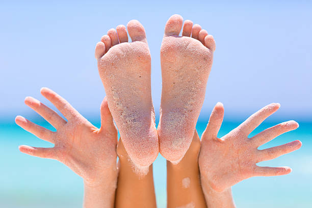 istock Female hands and feet on sea background 533903942