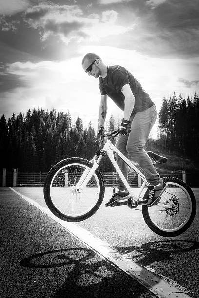 istock Man jump on bicycle through the white line 533904305