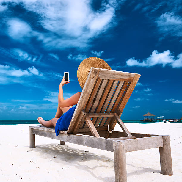istock Young woman with mobile phone at the beach 533910049