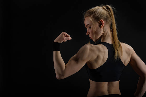 istock Young muscular woman posing on black 533919442