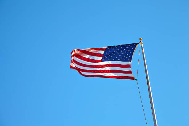 istock American flag waving in blue sky 533920938