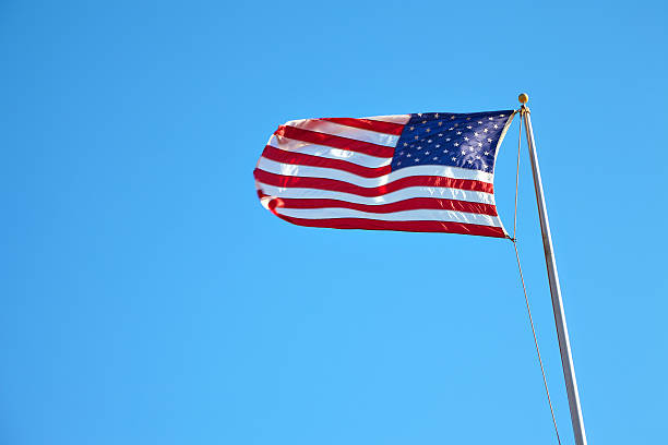 istock American flag waving in blue sky 533920992