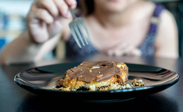 istock girl eating crushed donut cake with fork 533922436