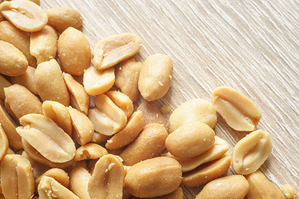 istock Roasted salted peanuts on wooden background 533922520