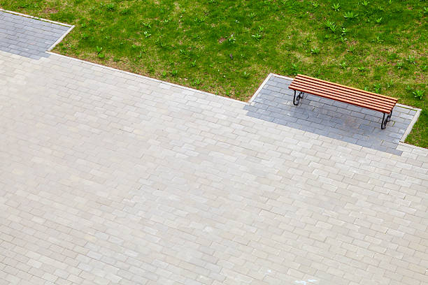 Empty wooden bench stands on cobblestone