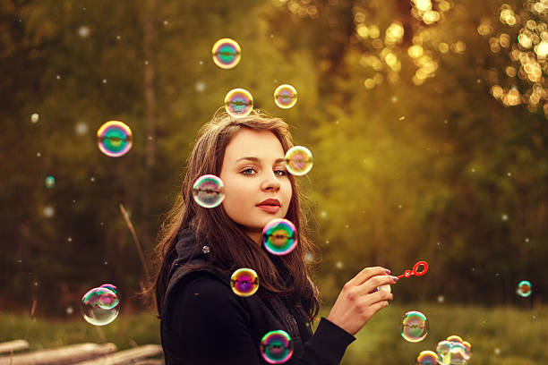 young girl in white shirt using bubble wand for fun