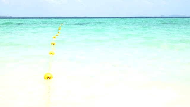 Yellow buoy with wave on the beach
